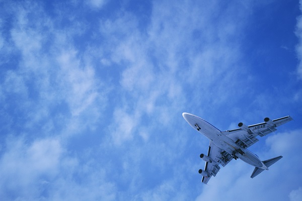 Grafika przedstawiająca samolot lecący po pięknym niebie